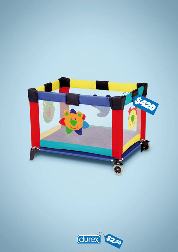 A 2009 Durex ad by agency Espirala DP. The background is a seamless light blue-gray. Against it, we see a brightly colored yellow and purple and teal and red packable playpen with happy cartoon animals on the side. A blue price tag is attached to the playpen: $420. Centered at the bottom of the ad is the Durex logo with its own blue price tag: $2.50. I know which one I’d choose.