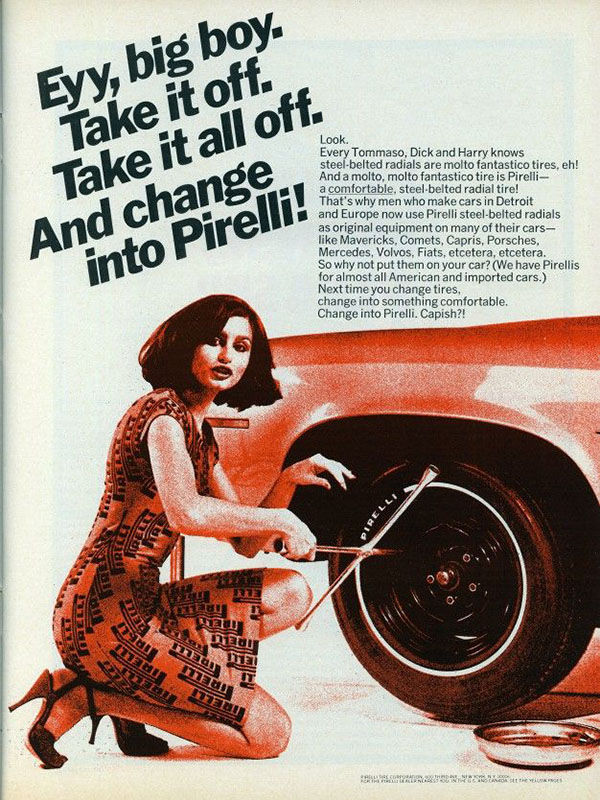 A 1974 Pirelli print ad. The ad, in black and red tones, shows the right rear fender and tire of a car. A brunette woman in a black-and-red dress and black slingback heels is crouched next to it with a tire iron, looking at the camera. The headline reads, “Eyy, big boy. Take it off. Take it all off. And change into Pirelli!”
The rest of the ad copy talks about the qualities and features of the tire, without any connection to the woman who’s apparently trying to seduce you into changing her tire for her.