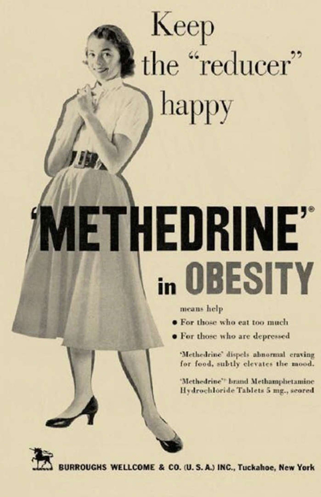 A very old ad, in black and white on a yellowed background. It shows a dark-haired woman in a white blouse, belted gray skirt, and sensible black pumps, hands clasped, with a big smile. To the right of her are the words, “Keep the ‘reducer’ happy,” Across the middle of the page, on top of her image, in large, black letters, are the words, “‘Methedrine’ for Obesity.” Below that, in smaller text, are the words, “For those who eat too much. For those who are depressed. ‘Methedrine’ dispels abnormal craving for food, subtly elevates the mood. ‘Methedrine’ brand Methamphetamine Hydrochloride Tablets 5mp, scored.” And at the bottom, in very small text, “Burroughs Wellcome & Co, (U.S.A.) Inc., Tuckahoe, New York”