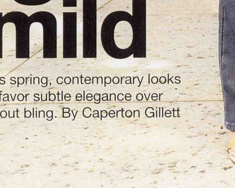 A very closely cropped image from the beginning of a magazine article. The words are too cropped to make out the full text, which is cropped from the intro copy of an article about spring contemporary looks and subtle elegance, but you can clearly see the words “By Caperton Gillett.” The text is laid over a photo, but all we can see is a beige concrete sidewalk and the very edge of a leg wearing jeans and yellow sandals.